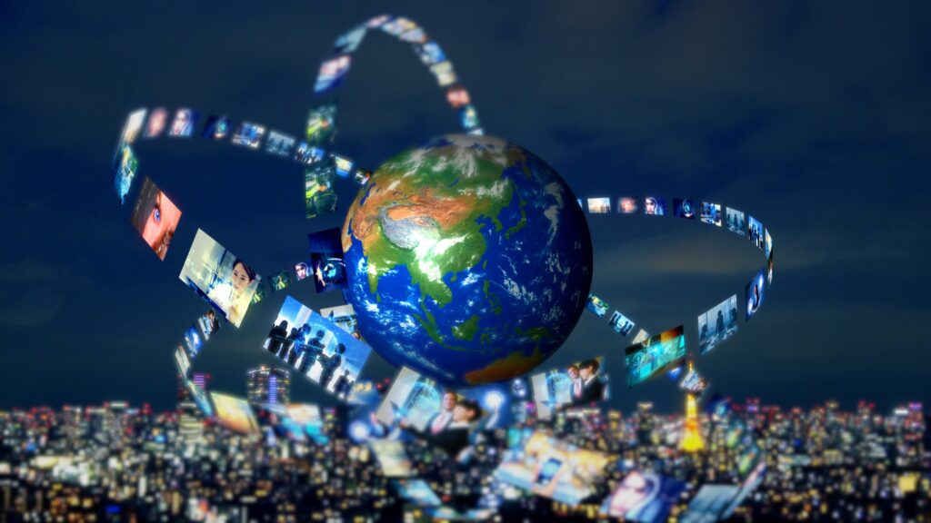 Earth with a circular orbit of photo thumbnails around it, symbolizing global media connectivity over a dark skyline.